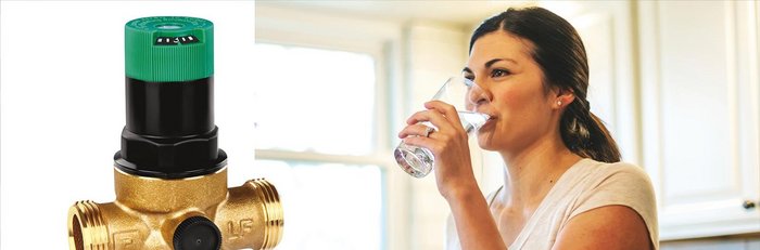 Ein Druckminderer der Pb Frei ist, rechts daneben ist eine Frau die ein Glas Wasser in der Küche trinkt