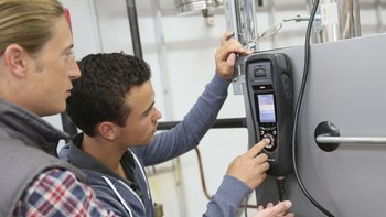 Zwei Anlagenmechaniker die eine Anlage mit einem Messgerät prüfen
