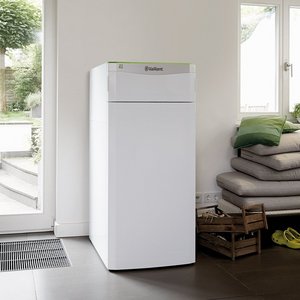 Ein moderner Kühlschrank steht in einem hellen Raum mit großen Fenstern, die auf einen gepflegten Garten blicken.